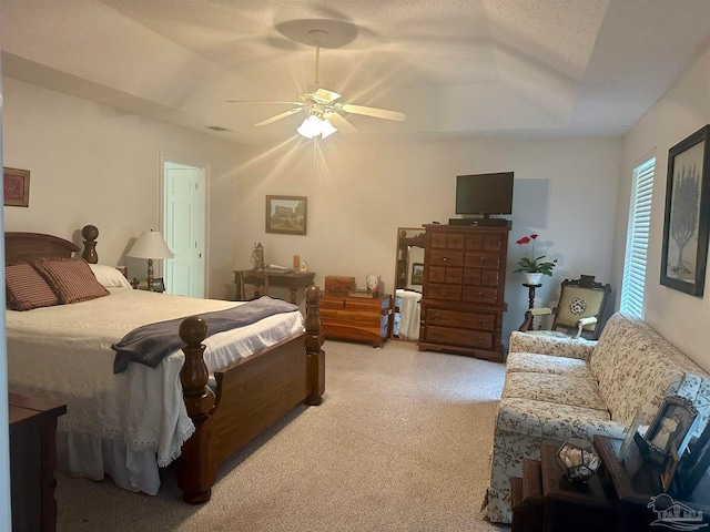 bedroom with a textured ceiling, light colored carpet, and ceiling fan