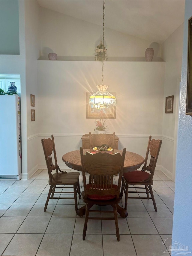 dining room with vaulted ceiling and light tile patterned flooring