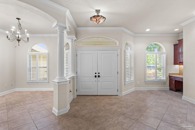 4166 Madura Four, Gulf Breeze, FL 32563 - foyer entrance featuring decorative columns, a chandelier, healthy amount of natural light, light tile patterned flooring, and crown molding