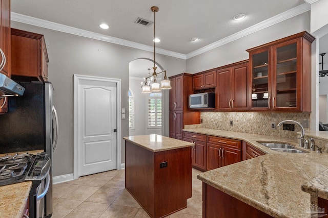 4166 Madura Four, Gulf Breeze, FL 32563 - kitchen featuring appliances with stainless steel finishes, a sink, arched walkways, backsplash, and light stone counters