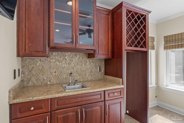 4166 Madura Four, Gulf Breeze, FL 32563 - kitchen featuring a sink, decorative backsplash, ornamental molding, glass insert cabinets, and light stone countertops