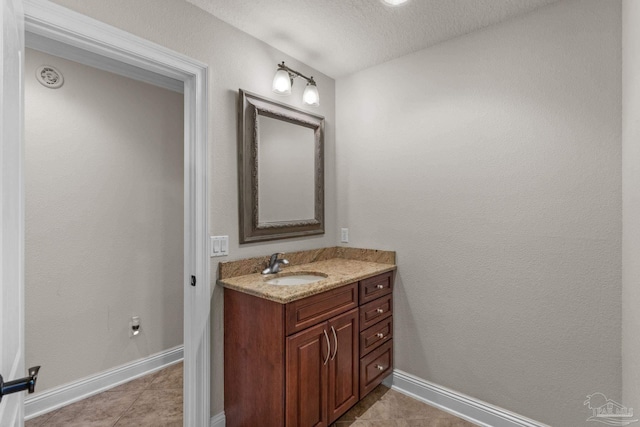 4166 Madura Four, Gulf Breeze, FL 32563 - bathroom with baseboards, vanity, a textured ceiling, and tile patterned floors