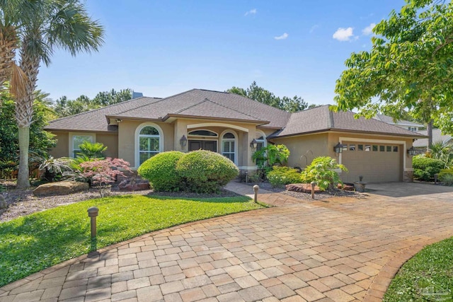 4166 Madura Four, Gulf Breeze, FL 32563 - view of front of property with stucco siding, decorative driveway, an attached garage, and a front lawn