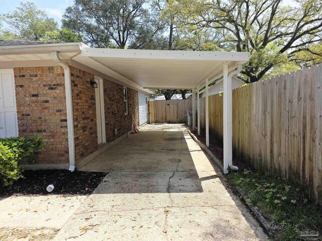 5666 Vestavia Ln, Pensacola, FL 32526 - view of patio / terrace with concrete driveway, an attached carport, and fence