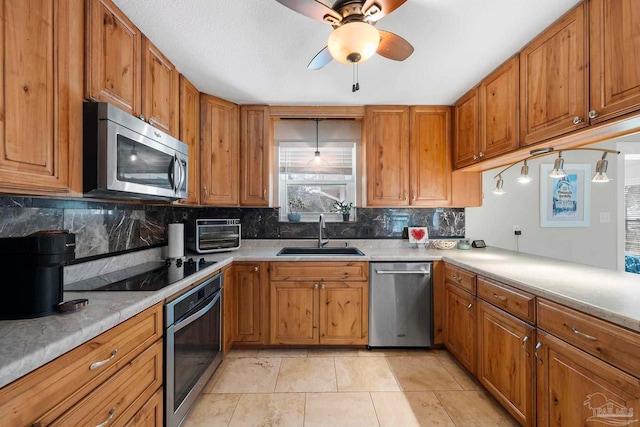 kitchen featuring light tile patterned flooring, sink, tasteful backsplash, appliances with stainless steel finishes, and ceiling fan