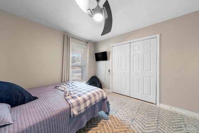 bedroom featuring carpet floors, a textured ceiling, ceiling fan, and a closet