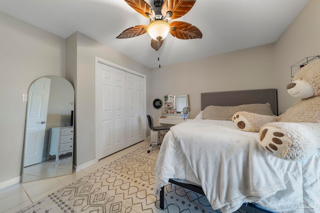 tiled bedroom with ceiling fan and a closet