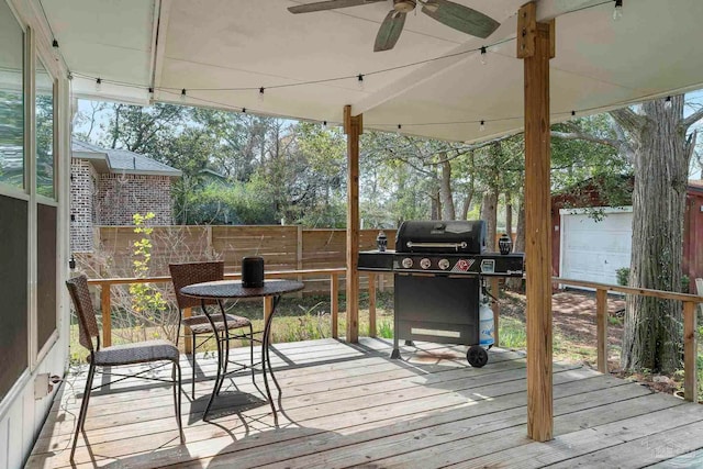 wooden terrace with area for grilling and ceiling fan