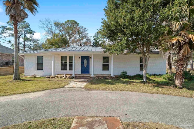 ranch-style home with a front lawn and covered porch