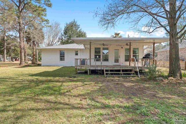 rear view of property featuring a yard, ceiling fan, and a deck