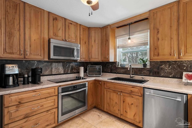 kitchen featuring tasteful backsplash, appliances with stainless steel finishes, sink, and hanging light fixtures