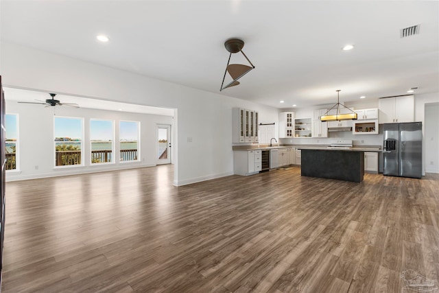 unfurnished living room featuring dark hardwood / wood-style floors, sink, and ceiling fan