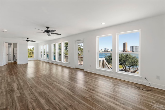 unfurnished living room featuring wood-type flooring and ceiling fan