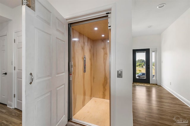 hall featuring elevator and dark hardwood / wood-style flooring