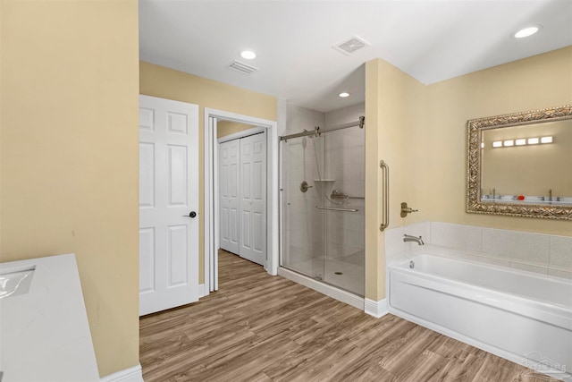 bathroom featuring vanity, shower with separate bathtub, and wood-type flooring