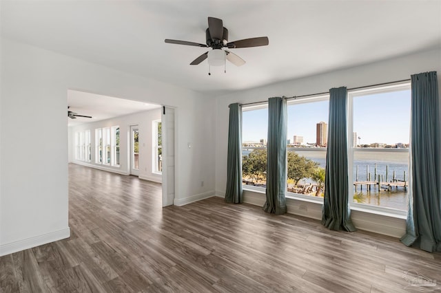 spare room featuring hardwood / wood-style flooring, a water view, and a wealth of natural light