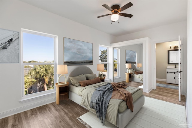 bedroom featuring sink, light wood-type flooring, and ceiling fan