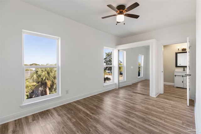 unfurnished bedroom with light hardwood / wood-style flooring, sink, and ceiling fan