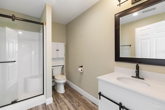 bathroom with vanity, hardwood / wood-style floors, toilet, and walk in shower