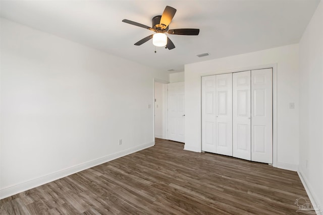 unfurnished bedroom with a closet, ceiling fan, and dark hardwood / wood-style floors