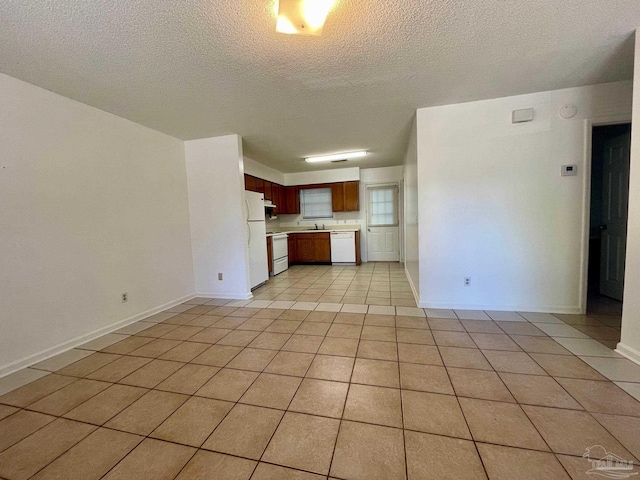 interior space featuring light tile patterned floors, a textured ceiling, and sink