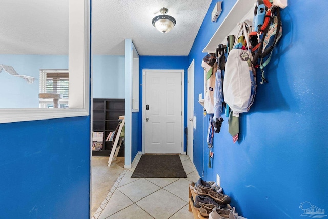 6555 Bellview Pines Pl, Pensacola, FL 32526 - doorway to outside with a textured ceiling, tile patterned flooring, and baseboards