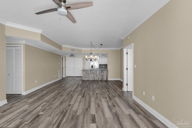 unfurnished living room featuring hardwood / wood-style floors, crown molding, and ceiling fan with notable chandelier