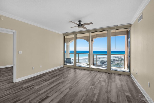 spare room with ceiling fan, a wall of windows, a wealth of natural light, and a water view