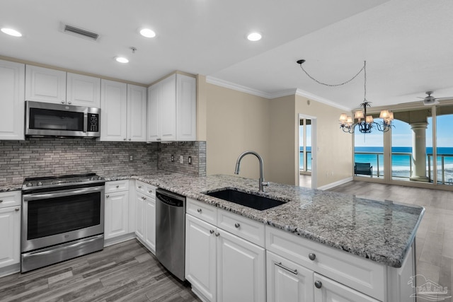 kitchen featuring kitchen peninsula, appliances with stainless steel finishes, white cabinetry, and sink