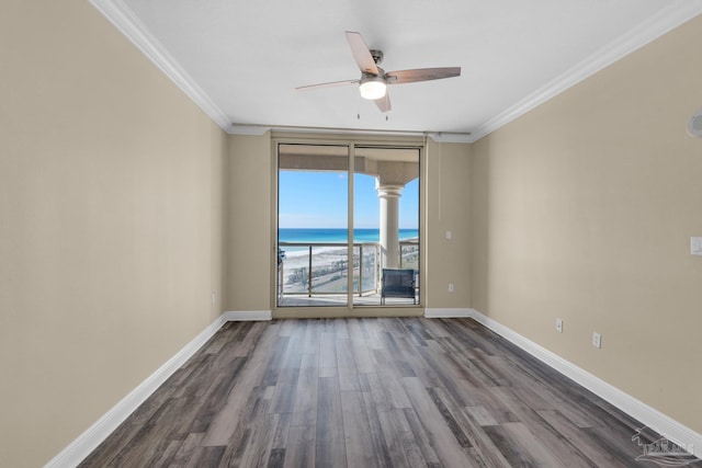 unfurnished room with ceiling fan, dark hardwood / wood-style floors, crown molding, and a water view