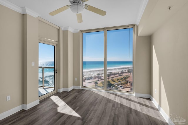 unfurnished room with a beach view, ceiling fan, a healthy amount of sunlight, and a water view