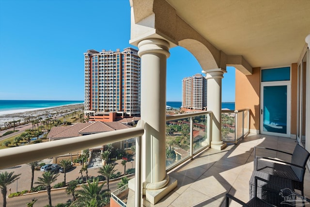 balcony featuring a view of the beach and a water view