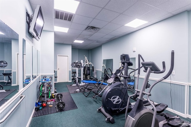 workout area with carpet floors and a drop ceiling