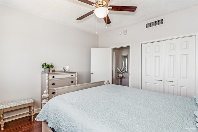 bedroom with ceiling fan, a closet, dark hardwood / wood-style floors, and a textured ceiling