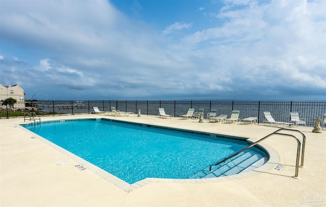 view of swimming pool with a water view and a patio