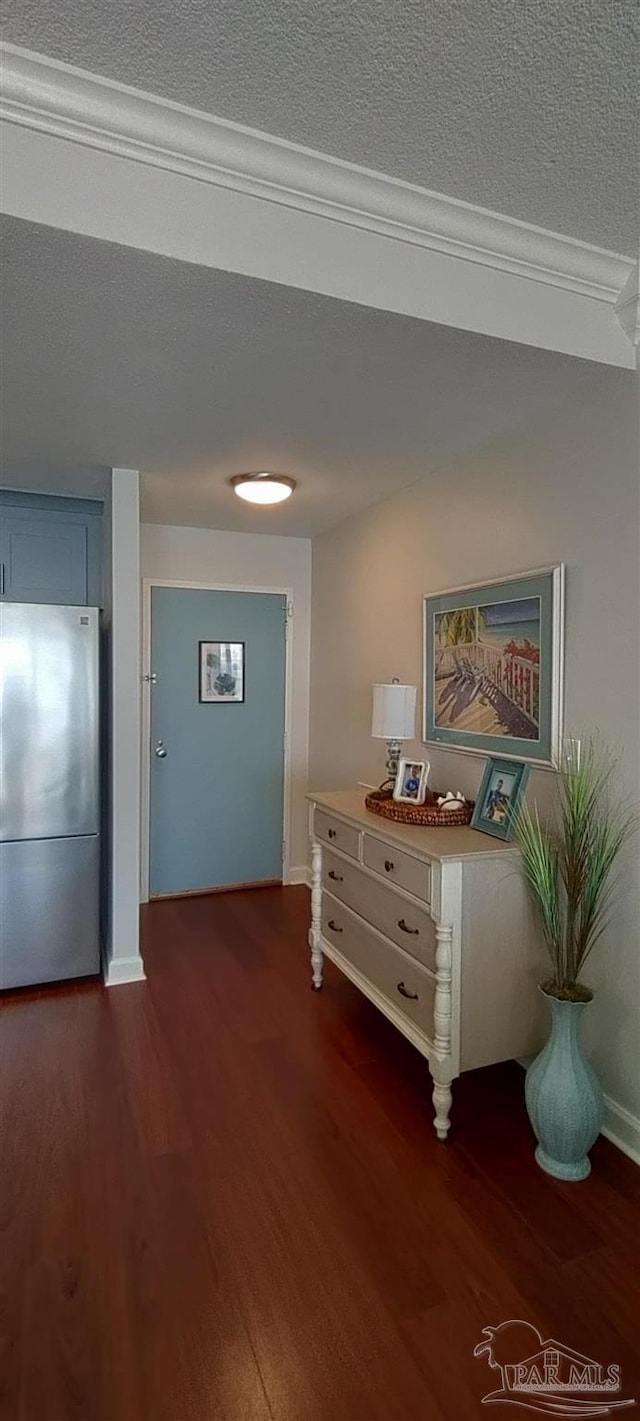 hallway with a textured ceiling, dark hardwood / wood-style flooring, and crown molding