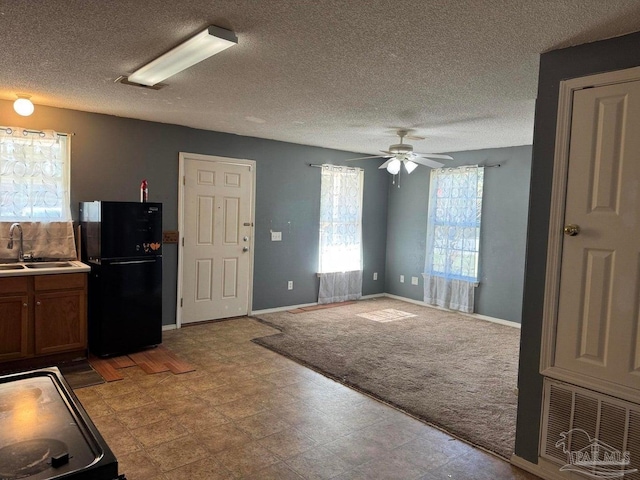 kitchen featuring freestanding refrigerator, a sink, a ceiling fan, range, and tile patterned floors