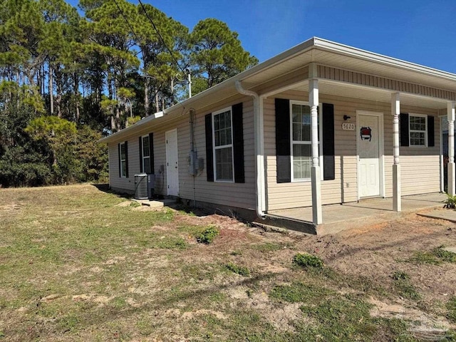 view of home's exterior with a lawn, central air condition unit, and covered porch
