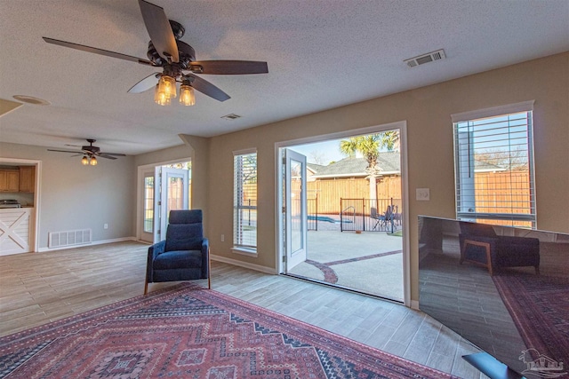 unfurnished room with ceiling fan and a textured ceiling