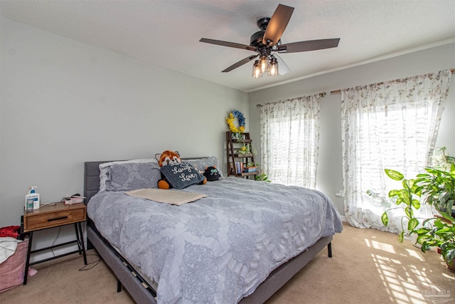 carpeted bedroom with ceiling fan and a textured ceiling