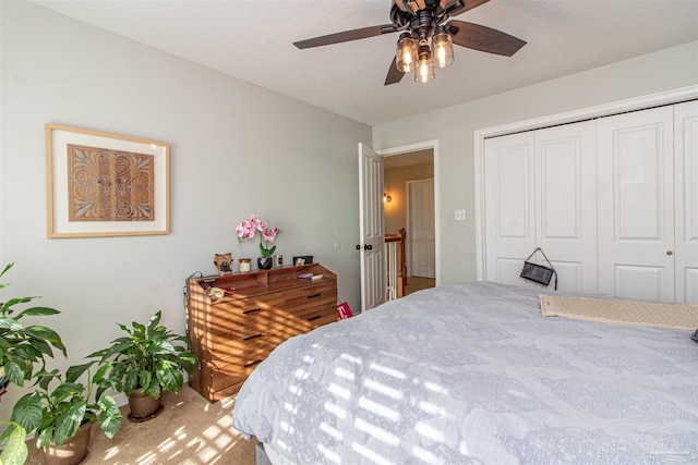 bedroom featuring ceiling fan, a closet, carpet floors, and a textured ceiling