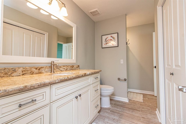 bathroom featuring hardwood / wood-style floors, vanity, and toilet