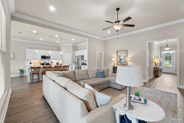 living room with ceiling fan, ornamental molding, baseboards, and dark wood-type flooring
