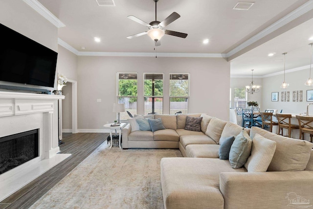 living area with dark wood-style flooring, visible vents, baseboards, ceiling fan with notable chandelier, and recessed lighting