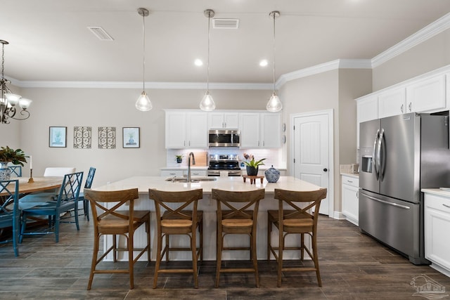 kitchen featuring visible vents, a sink, appliances with stainless steel finishes, and ornamental molding