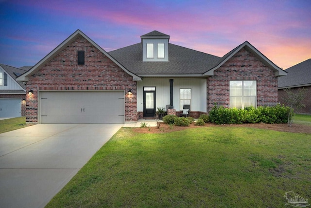 traditional-style house with roof with shingles, brick siding, concrete driveway, an attached garage, and a yard