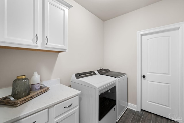 clothes washing area featuring separate washer and dryer, baseboards, dark wood-style floors, and cabinet space