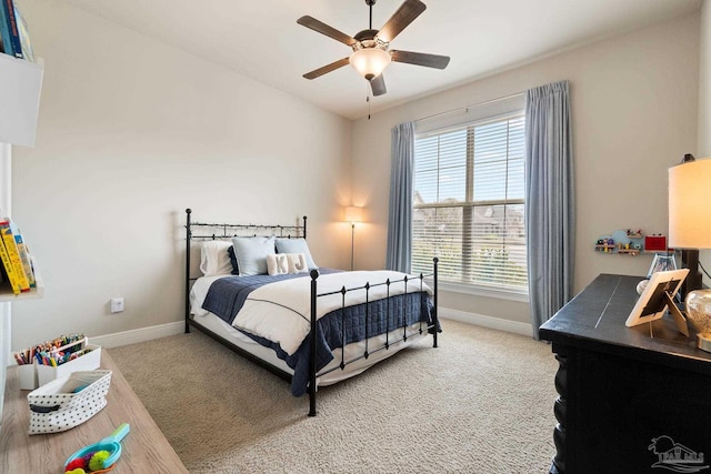 bedroom featuring baseboards, multiple windows, and light carpet