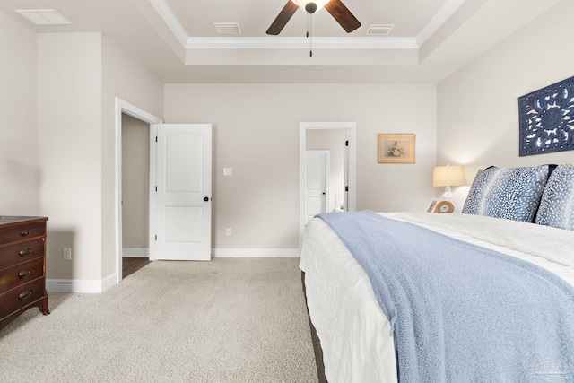 bedroom featuring crown molding, visible vents, light carpet, and a raised ceiling