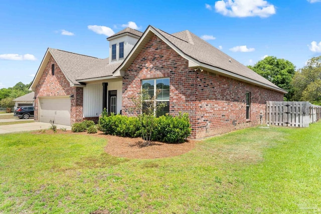 view of front of home with brick siding, fence, driveway, and a front yard